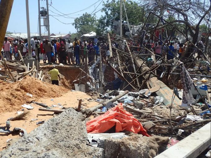 Anwohner stehen nach einem Sprengstoffanschlag vor einem Trümmerfeld. Explosion Autobombe in Mogadischu