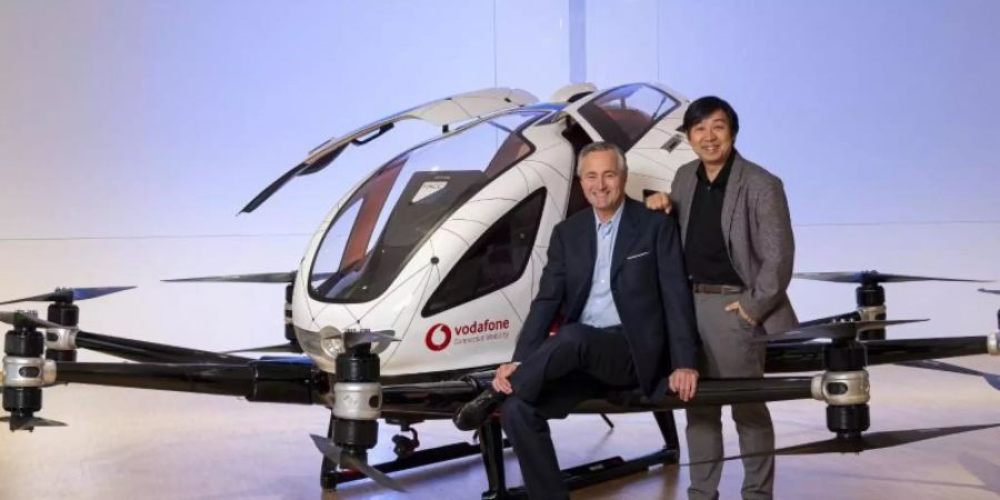 Vodafones Deutschlandchef Hannes Ametsreiter (l) und Hu Huazhi, Gründer und CEO von EHang, vor einem Flugtaxi des chinesischen Unternehmens. Foto: Guido Schroeder Fotografie/Vodafone/dpa