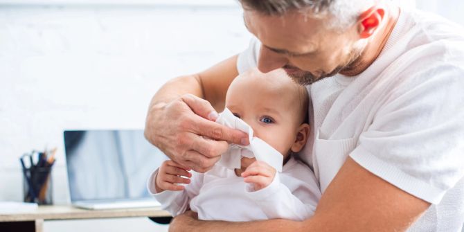 Papa mit Baby auf dem Arm