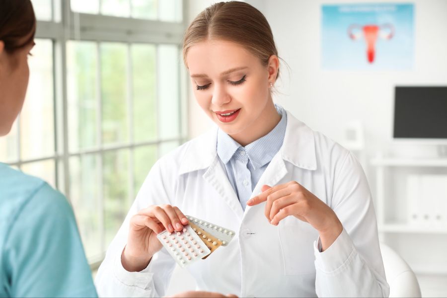 Gynäkologin mit einer Auswahl an Pillen spricht mit Patientin