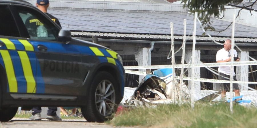 Polizisten und Feuerwehrleute stehen an der Absturzstelle eines Kleinflugzeugs nahe Ocová im Bezirk Zvolen. Beim Absturz eines Kleinflugzeugs in der Slowakei sind zwei Erwachsene und e...