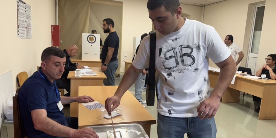 Ein Mann wirft bei der Parlamentswahl in Armenien seinen Stimmzettel in die Urne. Foto: Andre Ballin/dpa