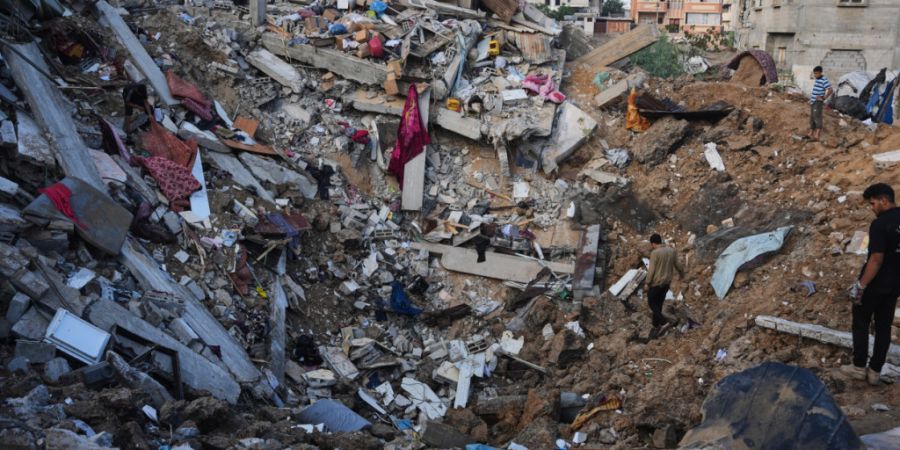 Palästinenser begutachten im Flüchtlingslager in der Mitte des Gazastreifens zerstörte Gebäude einen Tag nach einem israelischen Luftangriff. Foto: Abdel Kareem Hana/AP/dpa/Archivbild