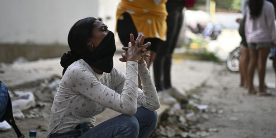Eine Frau wartet in der Nähe der Stadt La Guaira in Venezuela auf den Beginn der Rettungsmaßnahmen. Foto: Rafael Hernández/dpa