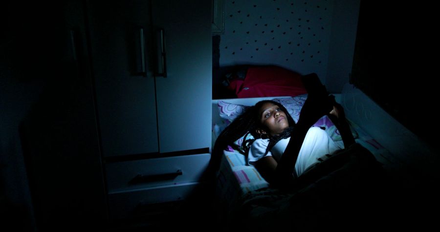 teenager mit handy im bett