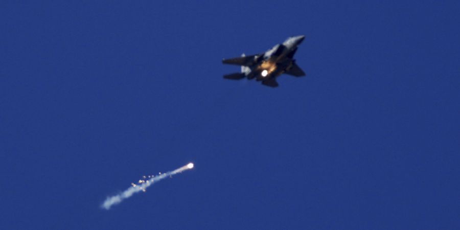 ARCHIV - Ein Kampfflugzeug der israelischen Luftwaffe feuert Leuchtraketen über dem Gazastreifen ab, zu sehen vom Süden Israels aus. Foto: Ariel Schalit/AP/dpa