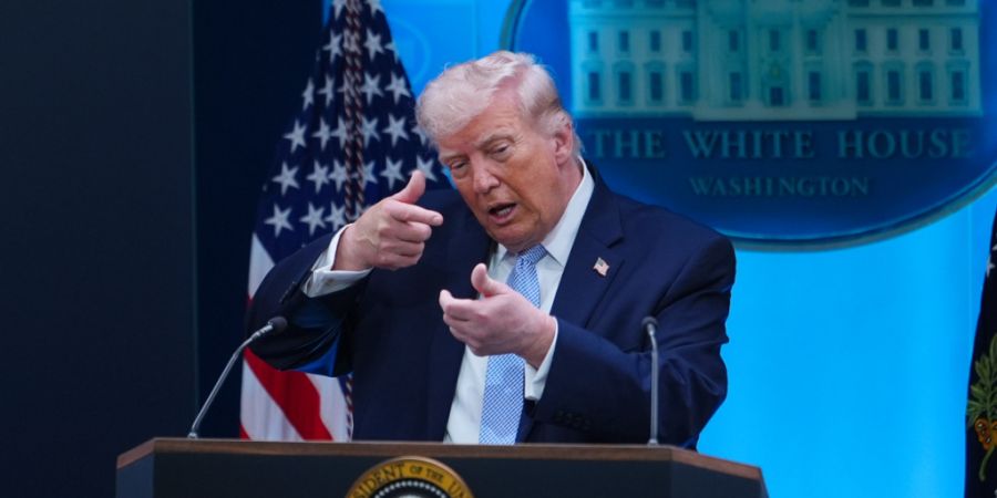 US-Präsident Donald Trump tut während einer Pressekonferenz im Weißen Haus so, als ziele er mit einem Scharfschützengewehr. Foto: Julia Demaree Nikhinson/AP/dpa