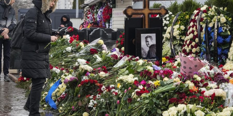 ARCHIV - Eine Frau legt einen Tag nach der Beerdigung von Alexej Nawalny auf dem Borissowskoje-Friedhof Blumen am Grab ab. Foto: Uncredited/AP/dpa