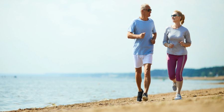 Paar joggt am Strand