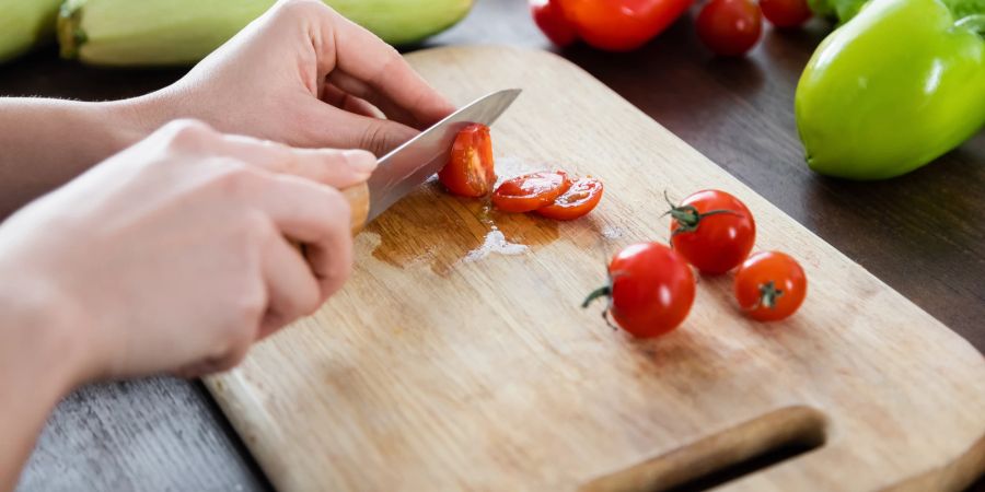 Schneidebrett, Hand schneidet Tomaten