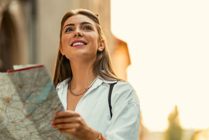 Lächelnde Touristin mit Stadtkarte