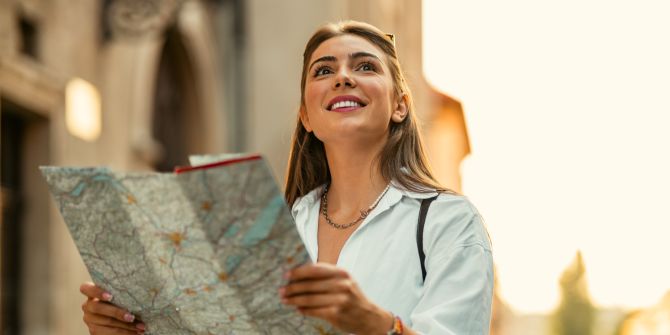 Lächelnde Touristin mit Stadtkarte