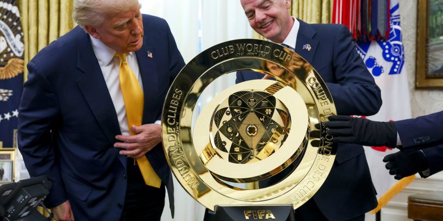 Der US-Präsident (l.) und der FIFA-Boss (r.) betrachten die Trophäe für die Club-WM.