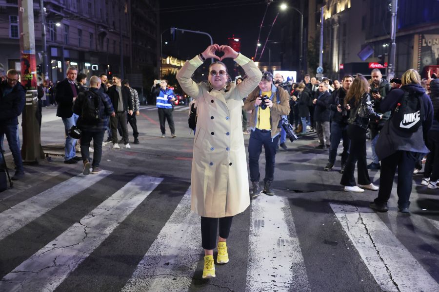 Eine Frau formt in der Belgrader Nacht ein Herz mit den Händen. Die Studentenliste soll laut Hochrechnung auf 130 der 250 Sitze kommen.