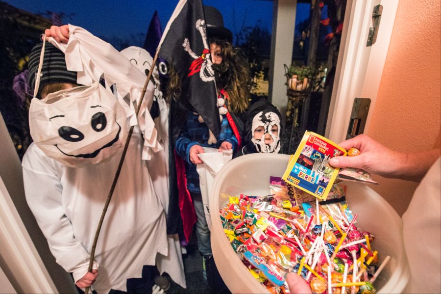 Beim Brauch «Süsses oder Saures» ziehen Kinder von Haus zu Haus und bitten um Süssigkeiten. Für viele steht Halloween heute vor allem für Kostüme, Dekorationen, Partys und Spass am Gruseln.