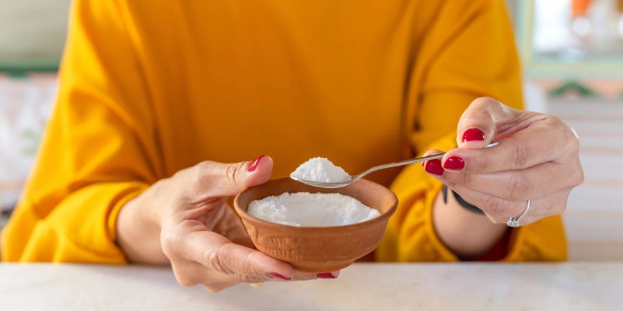 Frau hält Schale mit Zucker in der Hand