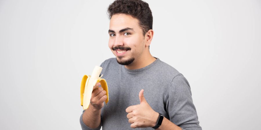 Lächelnder Mann mit geschälter Banane in der Hand