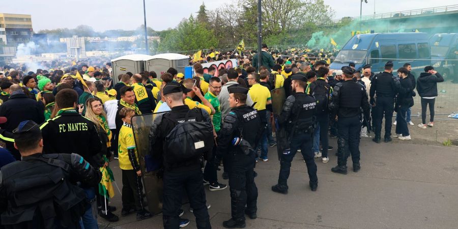 Polizisten stehen bei einer Gruppe von Fans des FC Nantes. Bei Zusammenstössen zwischen Fanlagern ist ein Fan ums Leben gekommen.