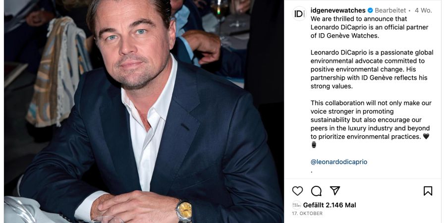 Leonardi DiCaprio in blauem Jacket und weissem Hemd und Luxusuhr an einem Tisch.