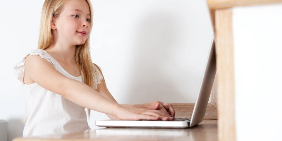 Mädchen mit Laptop am Tisch