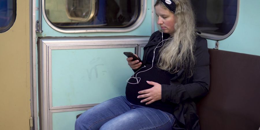 Schwangere Frau im öffentlichen Verkehr