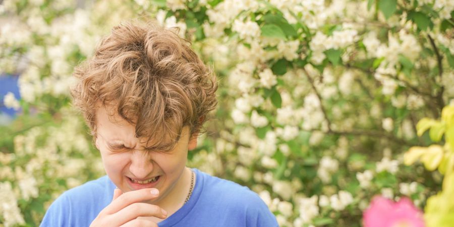 Junge niest im Freien