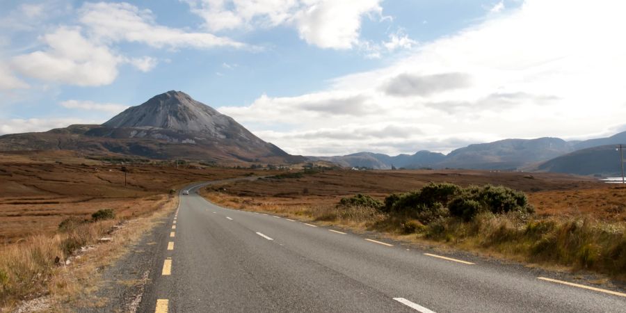 Gerade Strasse durch die Irischen Highlands mit Blick auf Mount Errigal.