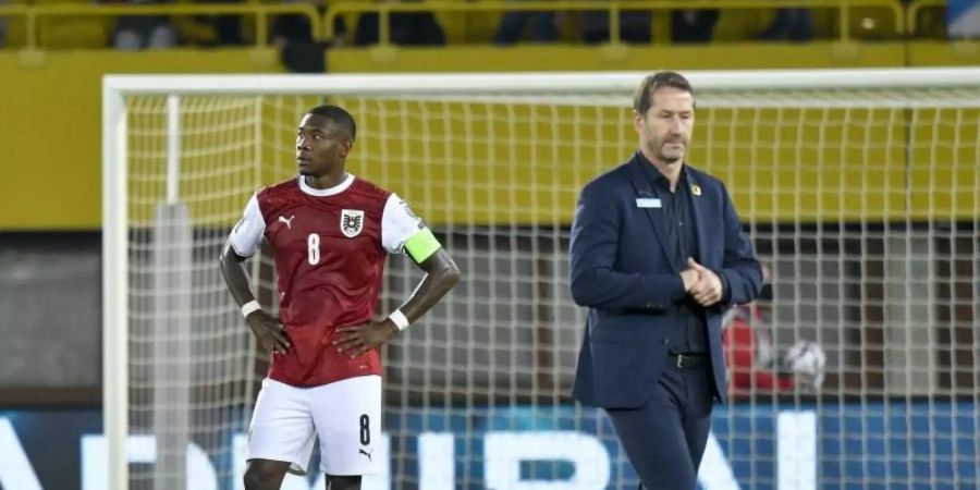 David Alaba (l) und Trainer Franco Foda stehen nach dem verlorenen Spiel gegen Schottland auf dem Platz. Foto: Herbert Neubauer/APA/dpa