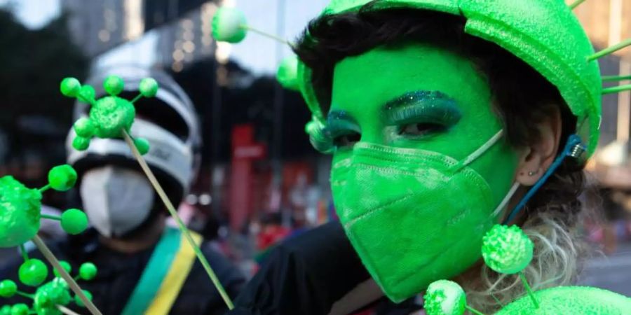 Ein Demonstrantin hat sich ihr Gesicht grün geschminkt und trägt eine grüne Schutzmaske. Tausende Brasilianer sind erneut gegen die Corona-Politik der Regierung von Bolsonaro auf die Strasse gegangen. Foto: Dario Oliveira/ZUMA Press Wire/dpa