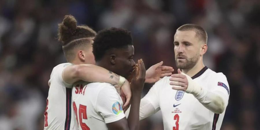 Untröstlich: Kalvin Phillips (l) und Luke Shaw (r) versuchen Bukayo Saka nach seinem Fehlschuss aufzurichten. Foto: Carl Recine/Pool Reuters/AP/dpa