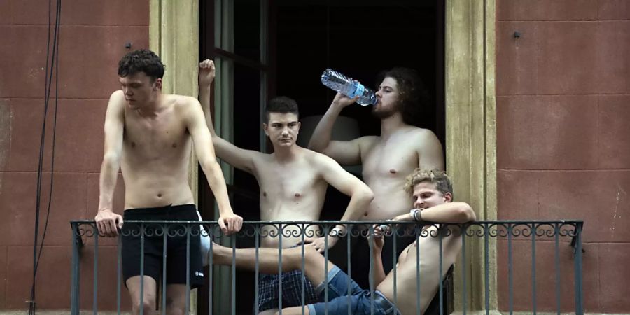 dpatopbilder - Jugendliche hängen auf einem Balkon ab. In einigen Teilen Spaniens wurden am Samstag Höchsttemperaturen von 46 Grad Celsius erwartet, während das Land am bisher heissesten Tag des Jahres schwitzte. Foto: Joan Mateu Parra/AP/dpa