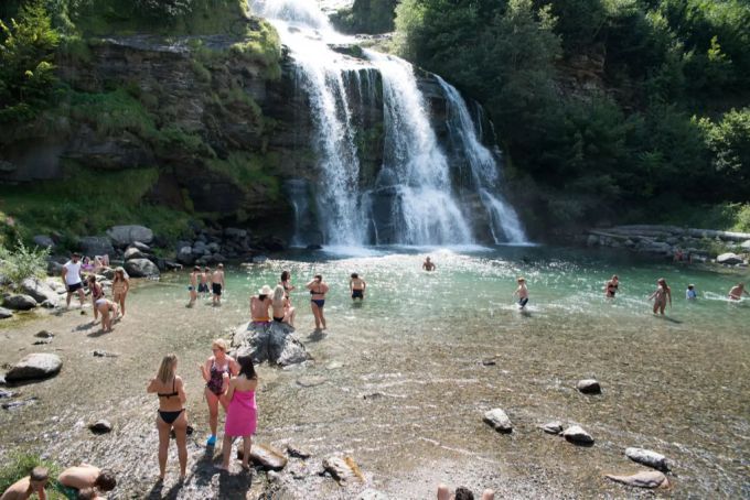 Badende suchen bei dem tollen Wetter mit Temperaturen über 30 Grad Abkühlung in den natürlichen Wasserbecken unter dem Wasserfall Piumogna bei Faido. Wasserfall Abkühlung Wetter