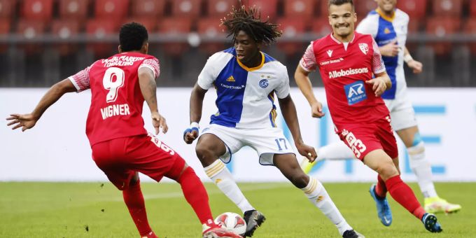 Grasshoppers Kaly Sene, Mitte, gegen FC Sions Vanger, links, und Kevin Bua, rechts, beim Fussballspiel der Super League zwischen dem Grasshopper Club Zuerich und dem FC Sion im Letzigrund Stadion in Zuerich am Sonntag, 26. September 2021. Grasshopper Club Zürich
