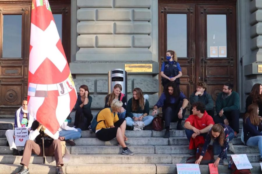 30 Massnahmenkritiker haben sich vor der Uni versammelt.