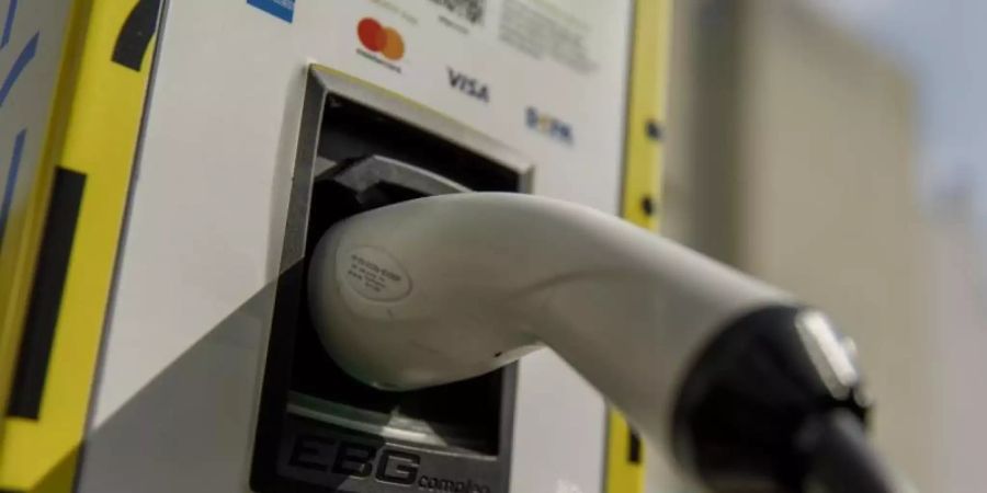 Ein Stecker eines Ladekabels steckt in einer Ladestation. Foto: Carsten Koall/dpa/Symbolbild