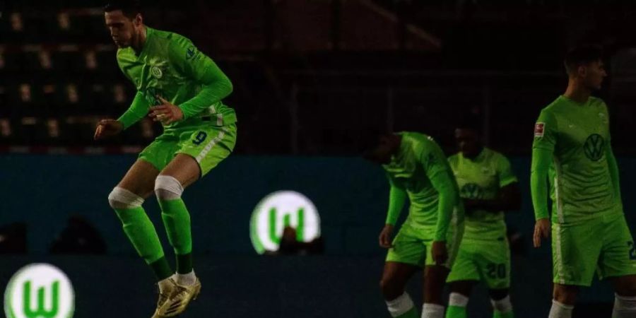 Das Logo vom VfL Wolfsburg leuchtet vor Spielbeginn auf Werbebanden, während die Spieler das Spielfeld betreten. Foto: Swen Pförtner/dpa