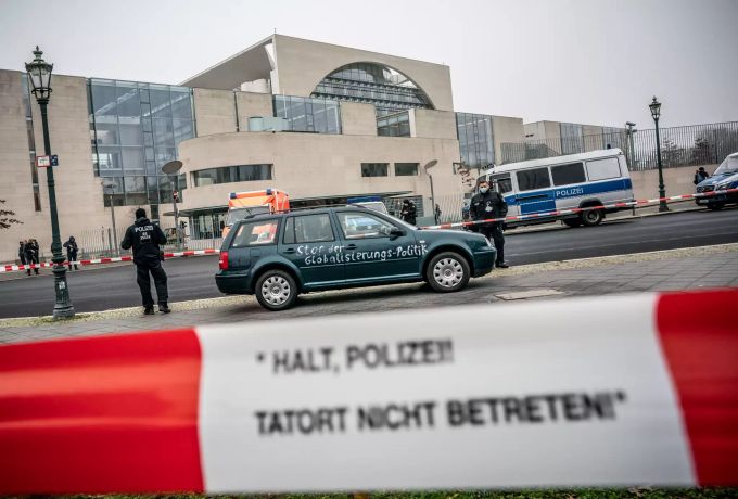Ein Auto, das zuvor gegen das Tor des Bundeskanzleramts gefahren war, steht vor dem Kanzleramt. Auf einer Tür des Fahrzeugs ist die Aufschrift «Stop der Globalisierungs-Politik» zu lesen. Auto mit Protest-Botschaft