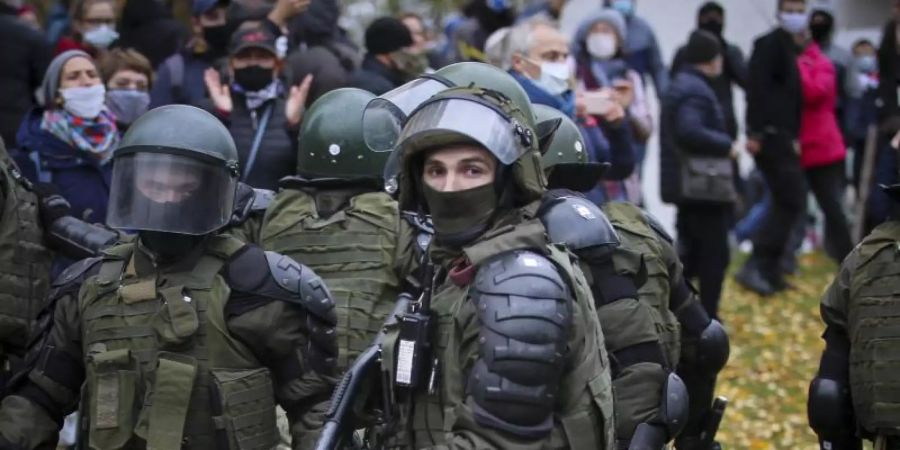 Sicherheitskräfte blockieren eine Strasse vor Demonstranten während einer Kundgebung der belarussischen Opposition. Foto: Uncredited/AP/dpa