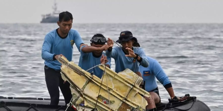 Taucher ziehen Trümmerteile aus dem Meer