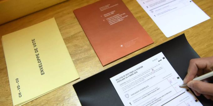 Eine Person füllt im Kanton Waadt einen Stimmzettel aus. Simmrechtsalter