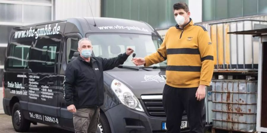 Jannik Könecke (r.) und Jörg Vespermann, Fahrlehrer und Geschäftsführer der Berufskraftfahrer-Akademie-Nord GmbH, stehen vor einem für grosse Fahrschüler umgebauten Fahrzeug. Foto: Julian Stratenschulte/dpa