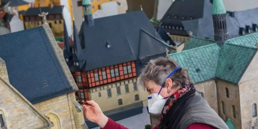 Andrea Herfurth, Gärtnerin beim Bürger- und Miniaturenpark Wernigerode, lackiert ein Modell der Sankt-Petri-Kirche, deren Original in Thale steht. Foto: Klaus-Dietmar Gabbert/dpa-Zentralbild/dpa