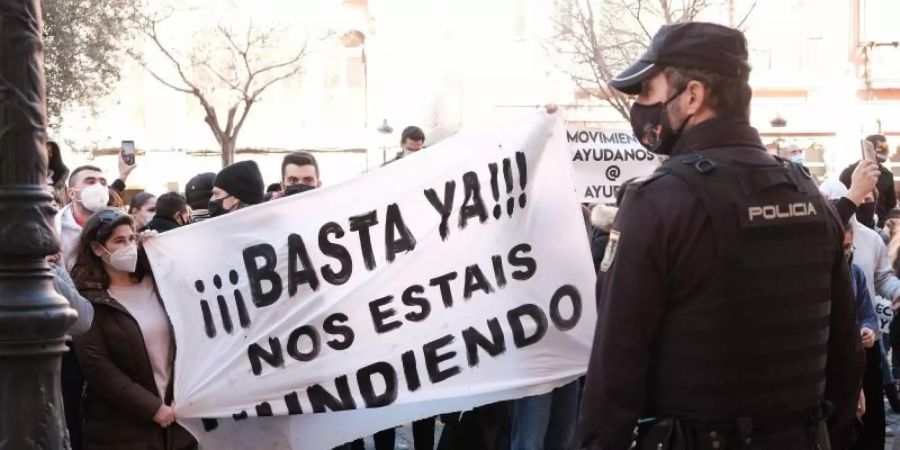 «Schluss damit, ihr ruiniert uns» steht auf einem Banner, das Demonstranten während einer Kundgebung gegen die Corona-Massnahmen in Palma de Mallorca halten. Foto: Isaac Buj/EUROPA PRESS/dpa