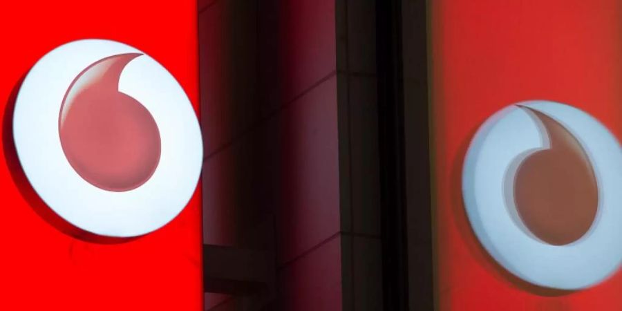 Das Logo von Vodafone spiegelt sich in der Fensterscheibe einer Verkaufsfiliale des Unternehmens. Foto: Rainer Jensen/dpa