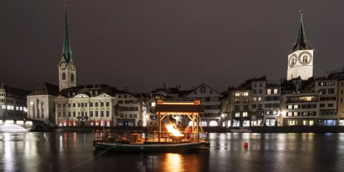 29.11.2020, Schweiz, Zürich: Karin Rykart, Stadträtin von Zürich, und Christoph Sigrist, Pfarrer des Züricher Grossmünsters, zünden zur Feier des 1. Advent ein «Hoffnungsfeuer» auf dem Fluss Limmat an. Weihnachtszeit in der Schweiz