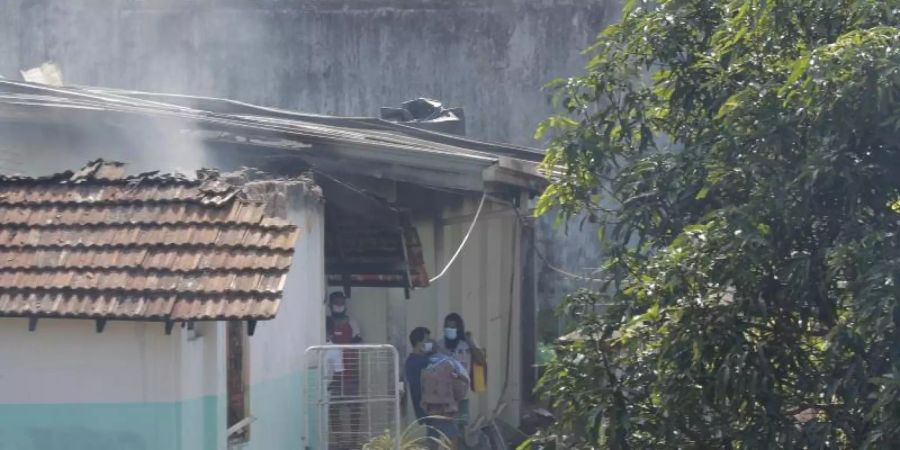Ein Gefängnis-Insasse trägt nach einem nächtlichen Aufstand im Gefängnis von Mahara, einem Vorort von Colombo, einen Mitgefangenen aus einem beschädigten Gebäude in Mahara hinaus. Foto: Eranga Jayawardena/AP/dpa