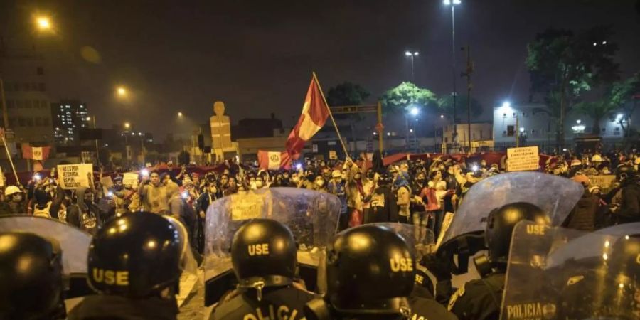 In Lima stehen sich Polizisten und Demonstranten gegenüber. Foto: Rodrigo Abd/AP/dpa