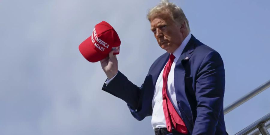 ARCHIV - Donald Trump, damaliger Präsident der USA, steigt am Internationalen Flughafen aus dem Flugzeug und winkt mit der «Make America Great Again»-Kappe. Foto: Evan Vucci/AP/dpa