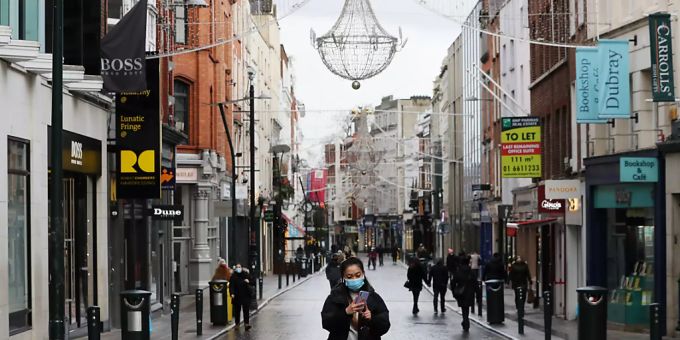Passanten mit Mund-Nasen-Bedeckungen gehen über die Grafton Street in Dublin. corona irland