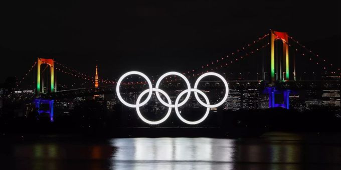 01.12.2020, Japan, Tokio: Die Olympischen Ringe beleuchten das Wasser unter der Rainbow Bridge. Das olympische Symbol wurde wieder angebracht, nachdem es vor den verschobenen Olympischen Spielen von Tokio 2020 zur Wartung abgenommen worden war. Foto: Du Xiaoyi/XinHua/dpa +++ dpa-Bildfunk +++ Vor den Olympischen Spielen in Japan 2021